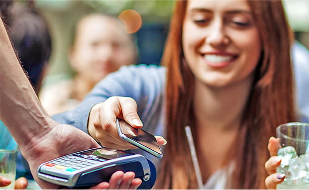 paying waiter at restaurant with phone