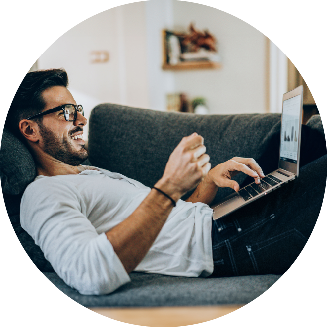man on couch with laptop making online purchase