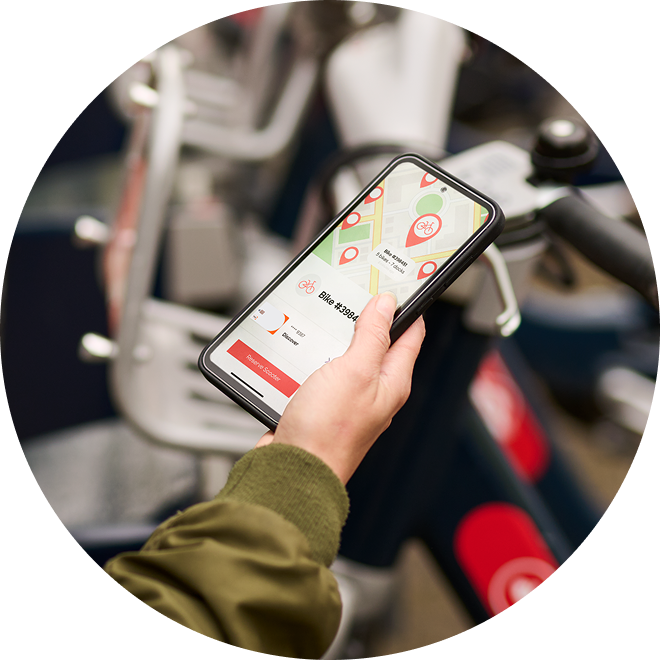 Hand holding a smartphone displaying a bike share app